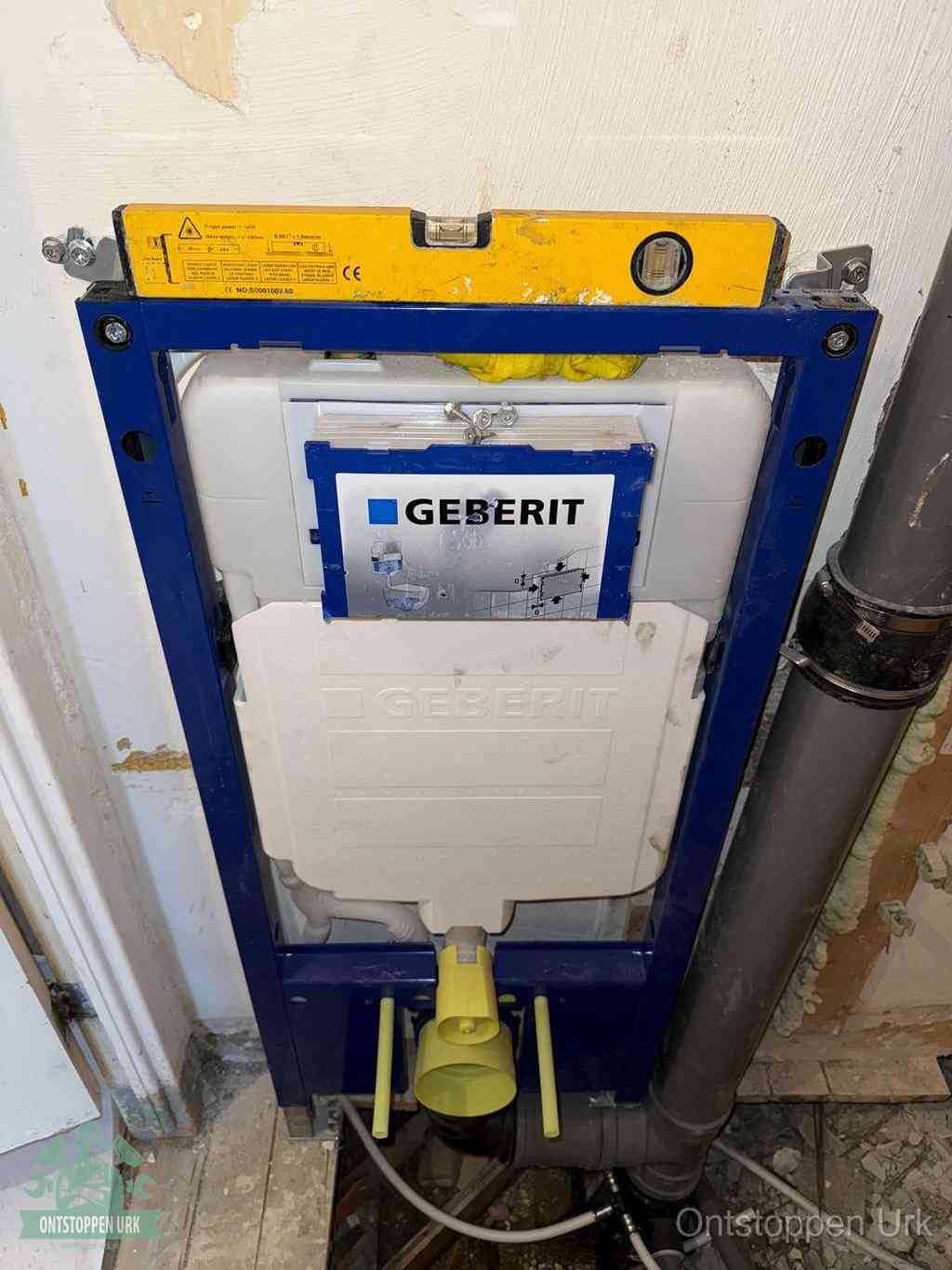 Een Geberit inbouwreservoir met frame voor een hangtoilet tegen de wand, met de afvoerbocht naar de vloer, kenmerkend voor een verstopt hangtoilet in Urk