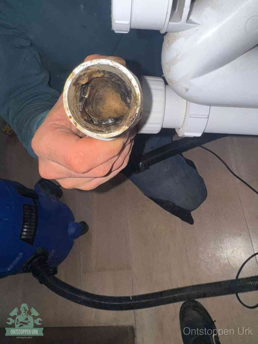 Een losgekoppelde afvoerbuis die van binnen volledig is dichtgeslibd met vet en aanslag, de meest voorkomende oorzaak van een verstopte gootsteen in Urk