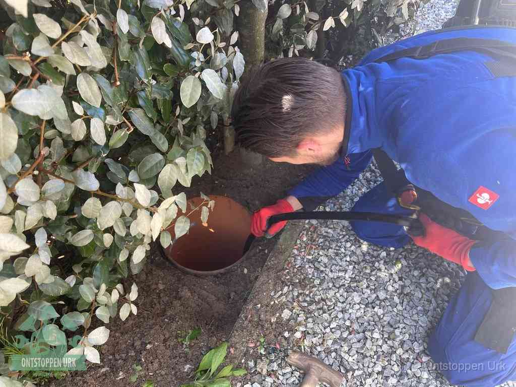 Monteur reinigt een rioolput met een slang, periodieke rioolreiniging in Urk