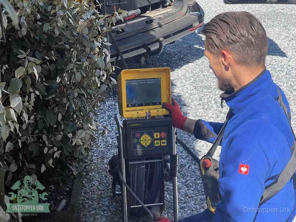 Monteur bedient een rioolinspectiecamera met monitor voor rioolinspectie in Urk