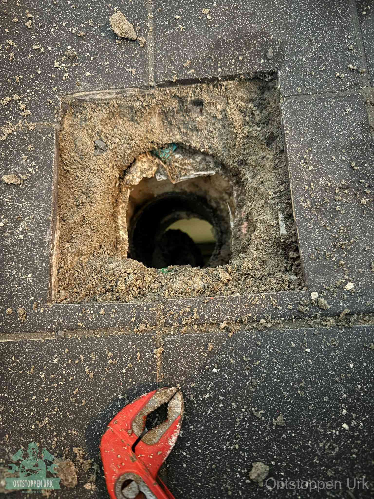 Geopend rioolputje op de erfgrens dat laat zien wie eigenaar is van de riolering in Urk