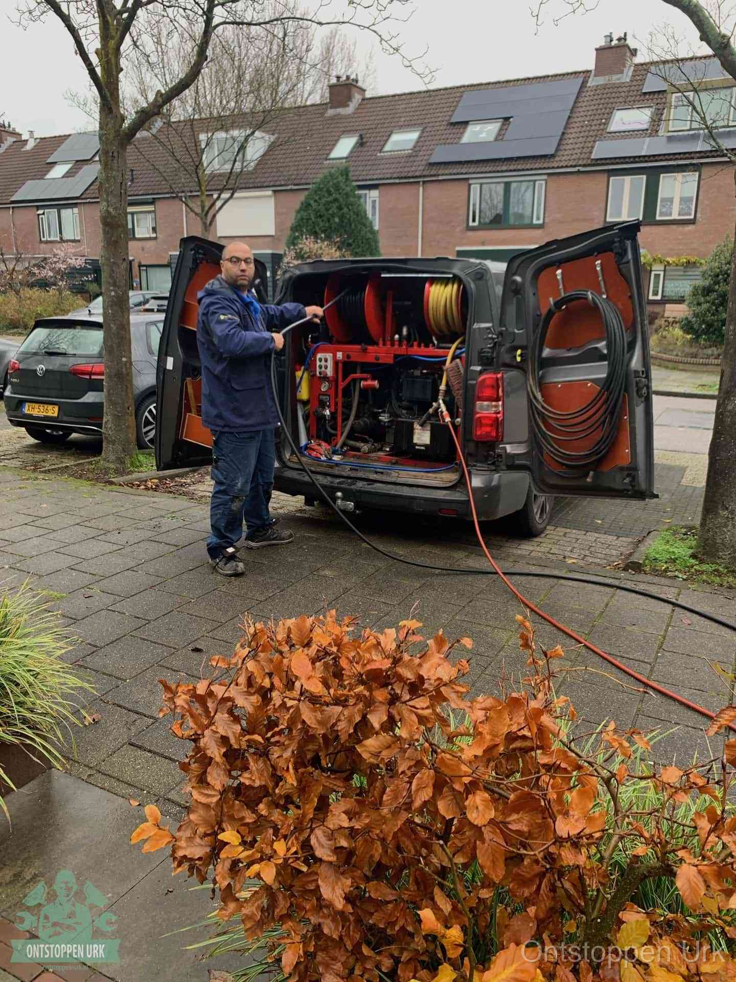 Monteur met rioolreinigingsbus levert rioolservice in de wijk in Urk