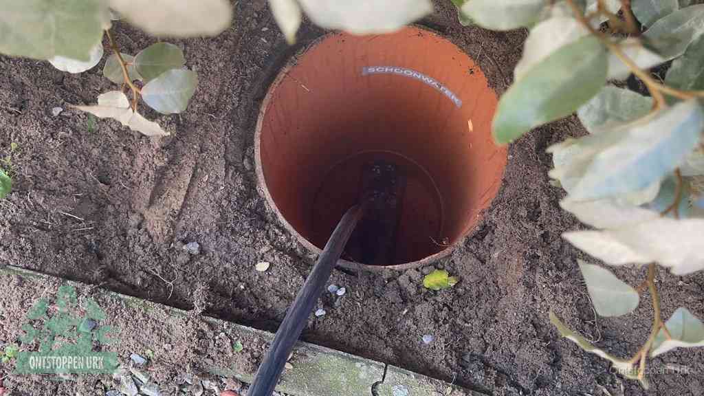 Open inspectieput in de tuin waar een veer rioolvliegjes en stankoverlast aanpakt in Urk