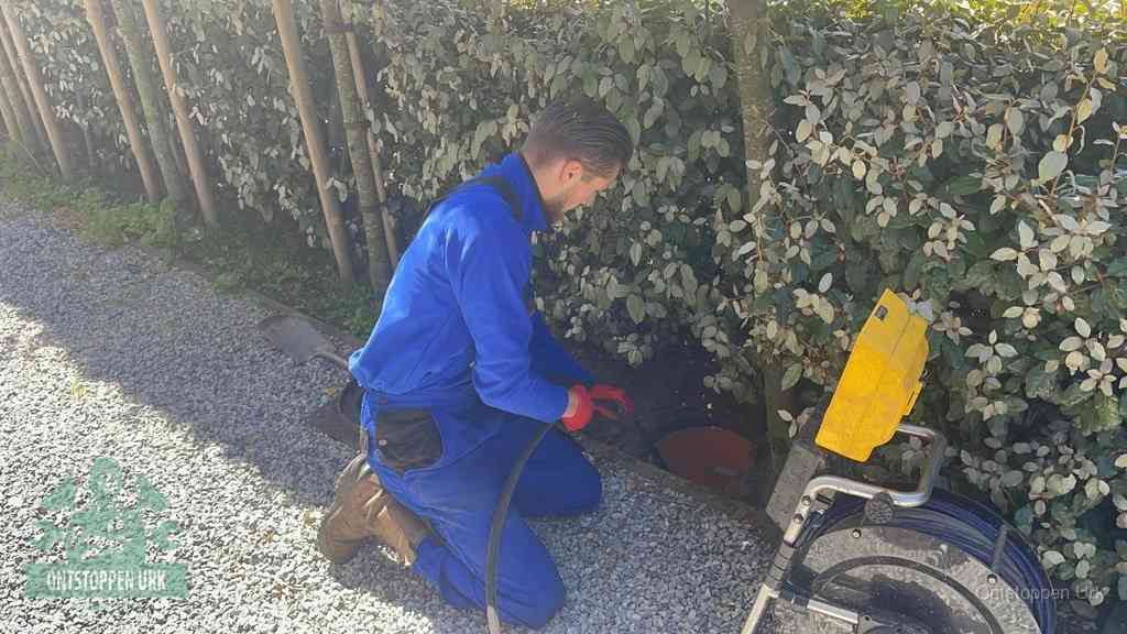 Monteur aan het werk bij een rioolput, de werkwijze voor riool ontstoppen in Urk