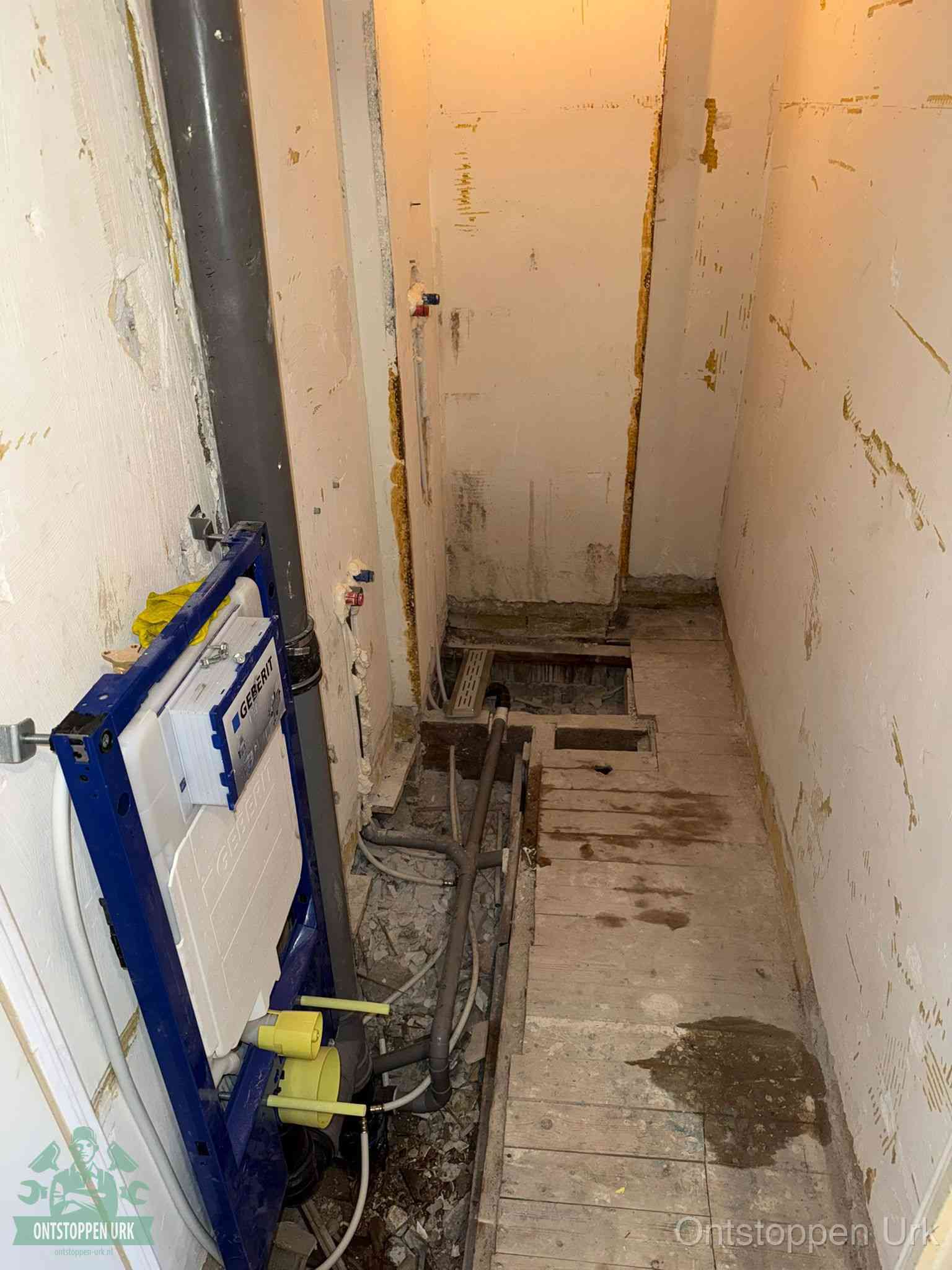 Een opgebroken toiletruimte tijdens renovatie met een Geberit inbouwreservoir en blootliggende oude afvoerleidingen, typisch voor oudere woningen in Urk