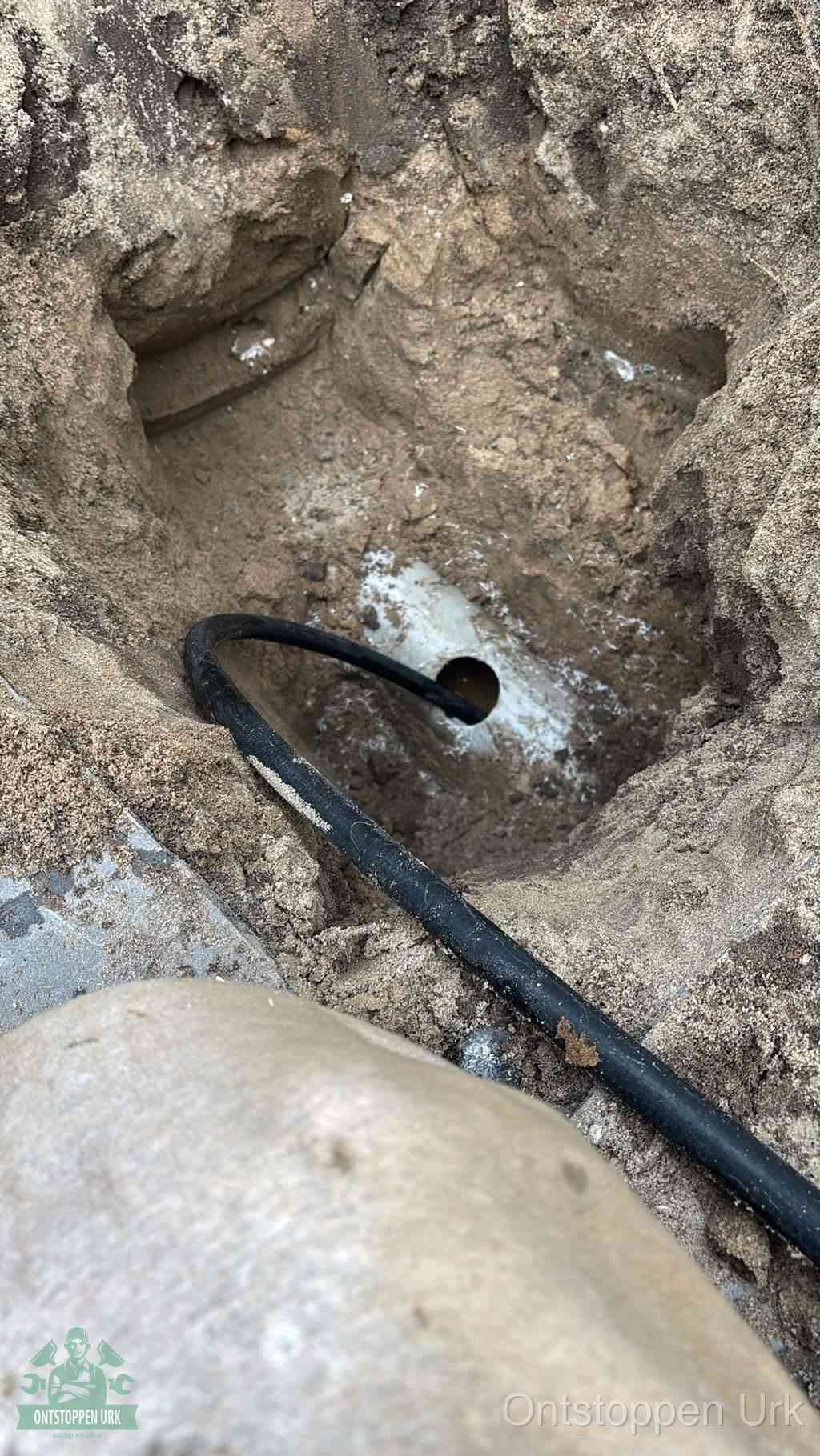 Uitgegraven rioolbuis in de grond, hulp om zelf het riool te ontstoppen in Urk
